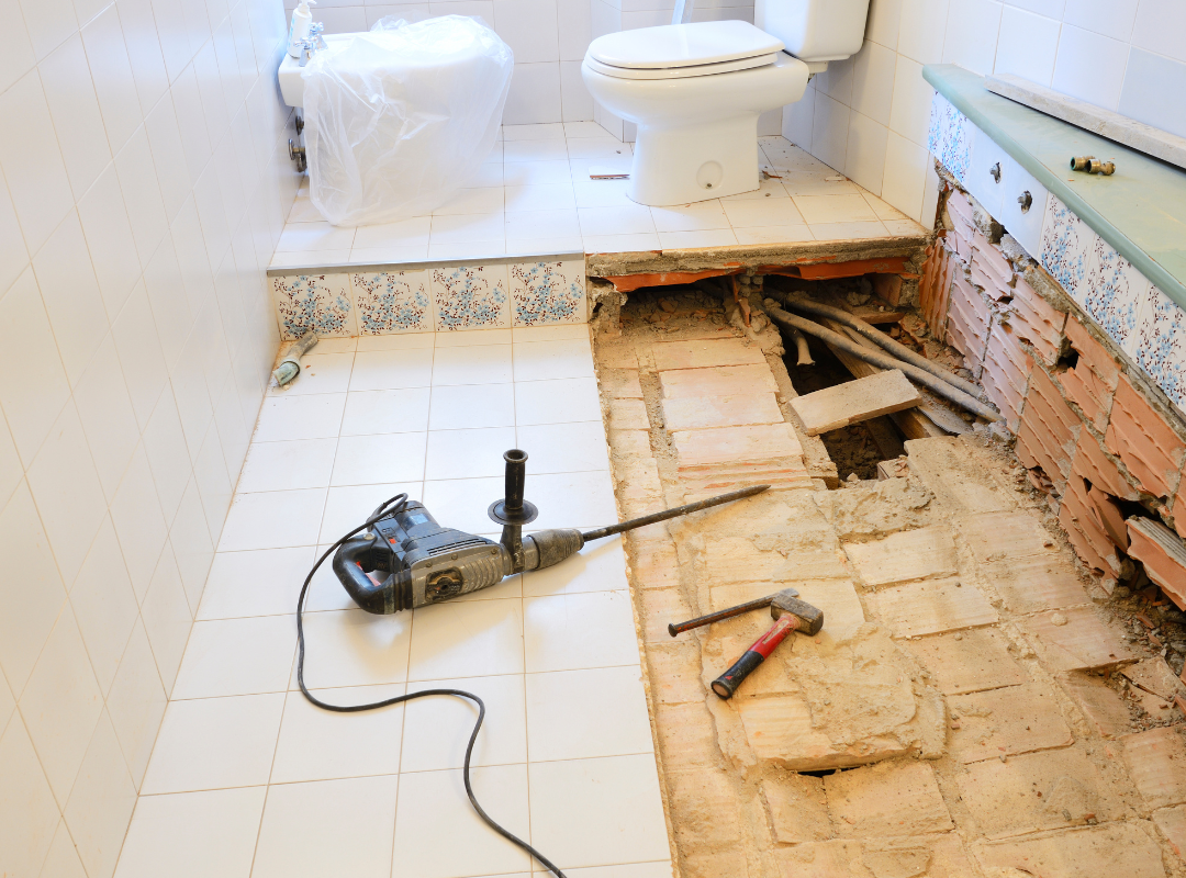 Renovering af badeværelse med nedrivning af gulv og forberedelse til nyt flise- og murerarbejde.